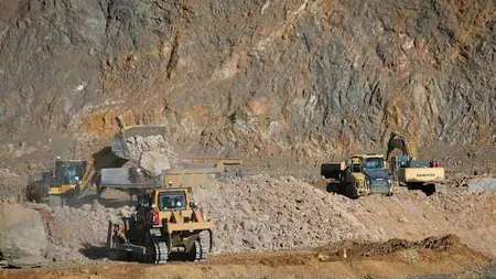 Wheel loaders and excavators move and load rocks into trucks at the MP Materials rare earth mine in Mountain Pass, California.